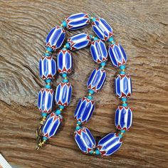 Venetian inspired Trade Blue Chevron and white heart Beads Strand  Other Names Chevron Beads SIX Layer Type of Object Drawn, multi-layered glass Color BLUE, RED, White  Approximate Age Late 20th century Overall   * Condition: Good to fair.   * See picture with Size measurement tool for size comparison.   * Strand Length 22 inches   * Brand: Unbranded   * Style: Beaded   * Type: Strand of beads Additional information: Venetian Chevron beads are the most beautiful, recognizable and collectable of all of the Venetian "Trade Beads." Chevrons beads are made by a multi-part process. They start with the making of the cane, then another color glass is added and then this is usually put into a 12 point star mold. This process is repeated for each additional layer on the bead.                 INFORM Chevron Beads, Star Mold, Object Drawing, Blue Chevron, Measurement Tools, Size Comparison, Trade Beads, Glass Color, Late 20th Century