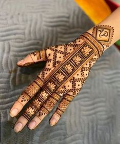 a woman's hand with henna tattoos on it