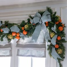 an orange and pine wreath hangs on the window sill