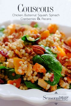 a white bowl filled with couscousa and spinach on top of a table