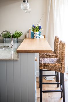 a kitchen counter with two chairs and a sink