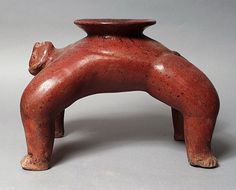 an old red pottery vase with a dog on it's back legs and feet