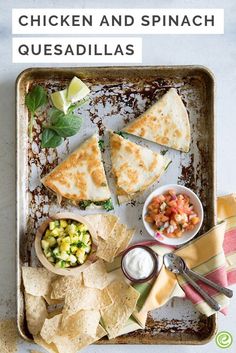 chicken and spinach quesadillas on a baking sheet with tortilla chips