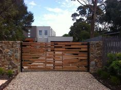 a wooden gate in front of a stone wall