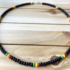 This Rasta Style Choker can be styled for a tropical vacation or relaxing at home. This simple yet bold look is an easy way to add a pop of color to an everyday outfit. All chokers are customizable to the size you need so please be sure to measure your neck where you want your choker to sit and order accordingly! This high quality beaded choker is beautiful worn on its own or layered. It is secured with a sterling silver lobster claw and made with glass beads that can stand the test of time, mak Casual Wooden Beads For Festival, Black Necklaces With Colorful Beads For Beach, Summer Beaded Necklace With Black Round Beads, Summer Black Beaded Round Necklaces, Casual Adjustable Wooden Beads, Black Beaded Necklace For Beach With Tiny Beads, Multicolor Large Beaded Necklaces For Vacation, Multicolor Large Beads Necklace For Vacation, Colorful Round Beads Casual Necklace