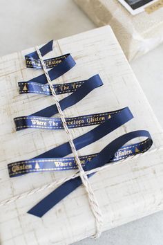 blue ribbon wrapped in white paper on top of a box