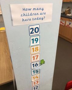 a child's fridge with numbers on it and a sign that says how many children are here today