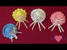 four crocheted flowers are sitting on a red surface