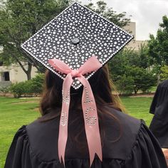 a woman wearing a graduation cap with white polka dots and pink ribbon on her head