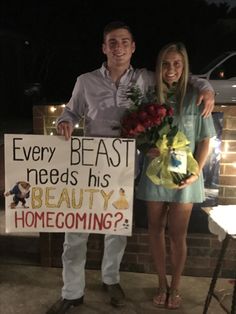 a man and woman standing next to each other in front of a sign that says, every beast needs his beauty home coming?