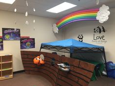 an indoor play area for children with toys and decorations on the walls, along with a rainbow theme