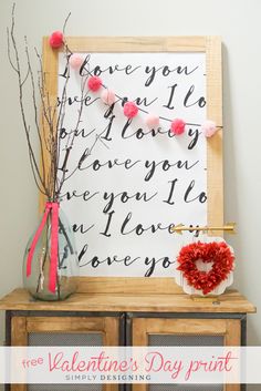 a valentine's day display with flowers and a heart on the sideboard next to it