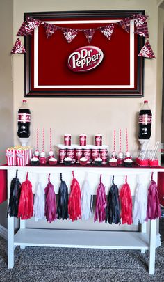 a red and white dessert table with soda pop decorations