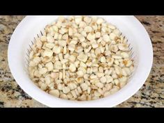 a white bowl filled with corn on top of a counter