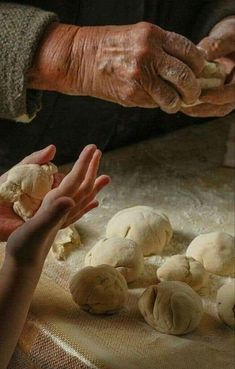 two hands reaching for mushrooms on a table with other hands in the foreground and another person holding out their hand to them