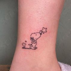 a small tattoo on the ankle of a person with a dog and star in it