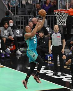 a man jumping up into the air to dunk a basketball in front of an audience