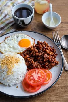 a plate with eggs, rice and tomatoes on it