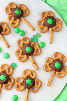 some pretzels are on a plate with green candies and shamrocks around them