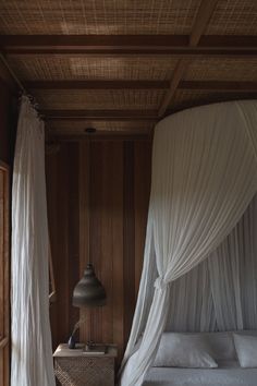 the canopy bed is made up with white drapes on it's headboard