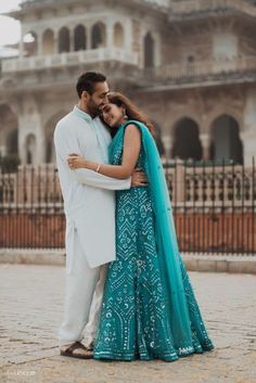 a couple embracing each other in front of a building