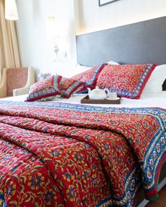 a bed with red and blue bedspread in a hotel room