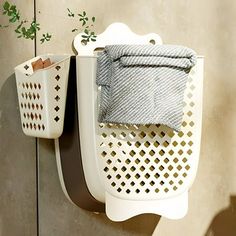 two white baskets are hanging on the wall