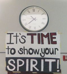 a sign that says it's time to show your spirit next to a clock