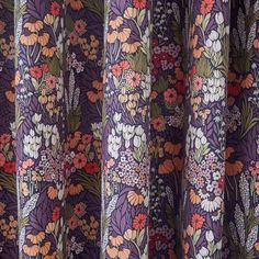 the curtains are covered with colorful flowers and leaves in purple, red, orange, yellow and green colors