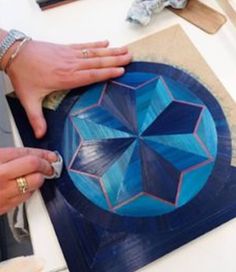 a person is painting an umbrella on a table