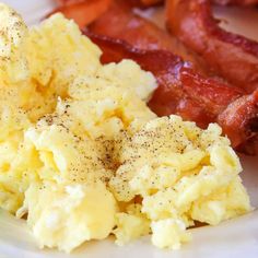 scrambled eggs and bacon on a white plate