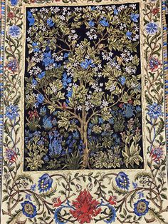 an intricately decorated tree with blue and red flowers in the center, on a black background