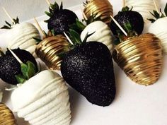 chocolate covered strawberries are arranged on skewers with gold leafy leaves and sprinkles