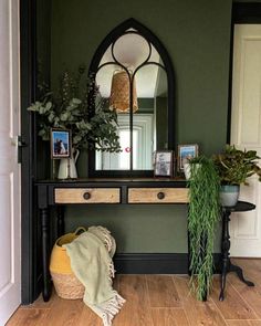 an entryway with a mirror, potted plants and a wicker basket