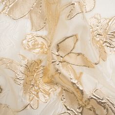 Float through your evening with an air of elegance thanks to this Metallic Gold and Gilded Beige Floating Flowers Luxury Burnout Brocade! Embossed flowers rise in the background and foreground of this luxurious fabric; the more opaque petals outlined in metallic gold grab your attention first while their discrete counterparts hide in the sheer beige backdrop. The face is three-dimensional and grainy, falling with a semi-structured drape—perfect as an elegant overlay for a gown or skirt. If complete opacity is desired, we suggest adding a silk habotai lining (for an added boost of luxury, too!). Organza Gold Flower, Luxury Gold Embroidered Elegant Fabric, Luxury Gold Embroidered Brocade Dupatta, Luxury Gold Embroidered Evening Fabric, Elegant Satin Finish Fabric For Wedding, Elegant Wedding Fabric With Satin Finish, Elegant Spring Party Fabric, Elegant Satin Fabric For Wedding, Elegant Wedding Satin Fabric