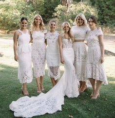 a group of women standing next to each other on top of a lush green field