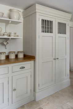 a kitchen with white cabinets and wooden counter tops