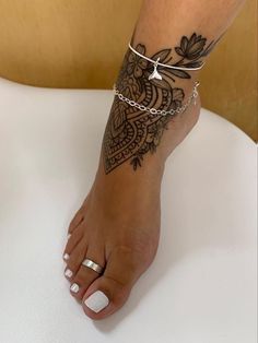 a woman's foot with a tattoo on it and a chain around the ankle