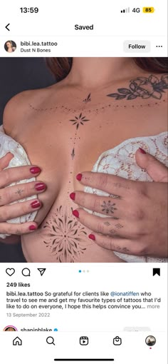 a woman's breast with tattoos on her chest and hands holding something in the other hand