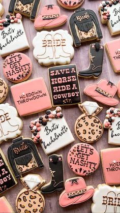 some decorated cookies are laying on a table with pink and white frosting, including black lettering