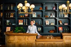 a woman standing at the front desk of a hotel