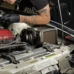 a man working on an engine in a car