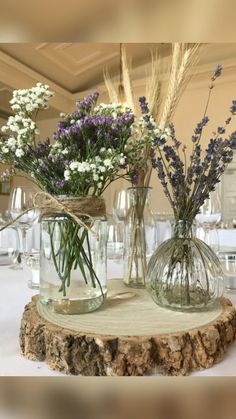 two vases filled with flowers sitting on top of a table