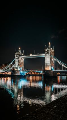 the tower bridge is lit up at night