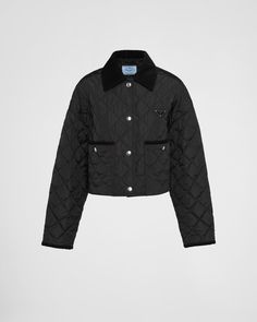 The timeless design of this quilted jacket is reinterpreted with a contemporary cropped silhouette. The pragmatic style is made of Re-Nylon, the innovative regenerated nylon fabric that is distinctive of Prada collections, obtained from recycled plastic materials collected in the ocean. Enhanced by corduroy collar and trim, the garment is embellished with the iconic signature touch of the enameled metal triangle logo. For sustainable care to preserve the product's characteristics and reduce micr Luxury Black Quilted Jacket, Designer Collared Outerwear With Snap Buttons, Luxury Outerwear With Contrast Collar And Long Sleeves, Designer Black Outerwear With Padded Collar, Luxury Outerwear With Padded Lapel Collar, Luxury Black Collared Outerwear, Black Corduroy Jacket, Prada Collection, Denim T Shirt