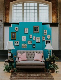 a living room with blue walls and pictures on the wall, couches and lamps