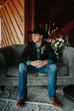 a man sitting on top of a couch wearing a cowboy hat