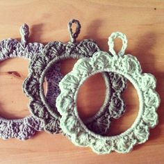 three crocheted ornaments sitting on top of a wooden table