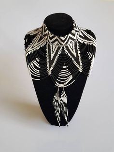 This shoulder necklace is made using black and white fine beads. Perfect for weddings or African themed events. **Buy multiple items and pay shipping for 1 item only.The rest ships free. More neckleces here; https://www.etsy.com/shop/TribalTess?ref=seller-platform-mcnav&section_id=21306083 Back to my shop; https://www.etsy.com/shop/TribalTess?ref=seller-platform-mcnav Unique White Choker Necklace, White Beaded Backdrop Necklace For Parties, Black Bohemian Beaded Necklaces For Weddings, Bohemian White Jewelry With Black Beads, White Beaded Choker For Wedding, Bohemian White Pearl Necklace For Party, Black Beaded Wedding Jewelry, White Bohemian Pearl Necklace For Party, White Beaded Chain Choker For Party