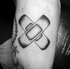 a black and white photo of a man's arm with a band aid tattoo on it